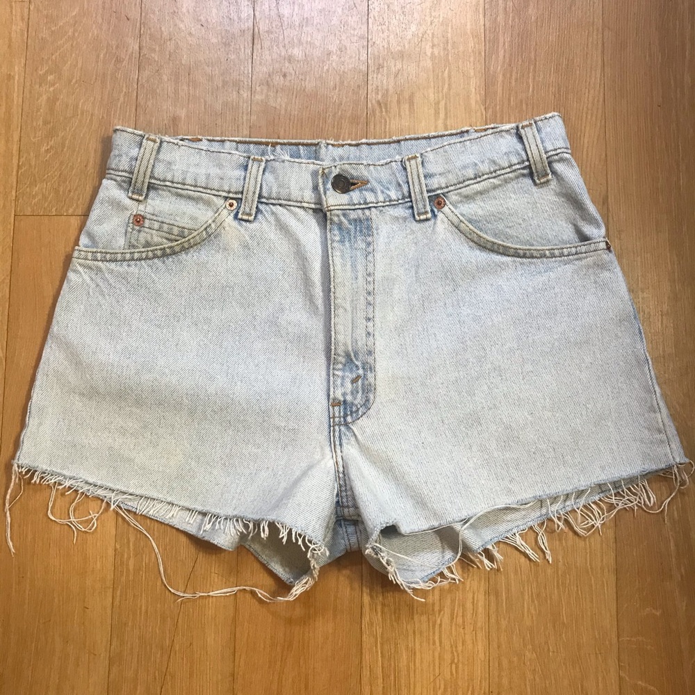 Vintage white-washed light denim Levi’s cut-offs with an orange tab, size 28.